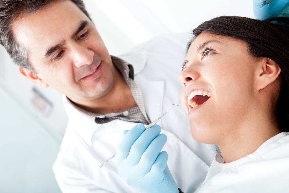 Dentist working on a female patient at his practice-1
