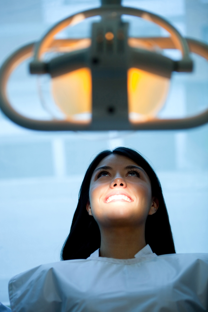 Girl at the dentist sitting on a chair under the light