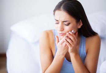 tooth pain woman holding mouth