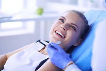 young woman at dentist with doctor smiling